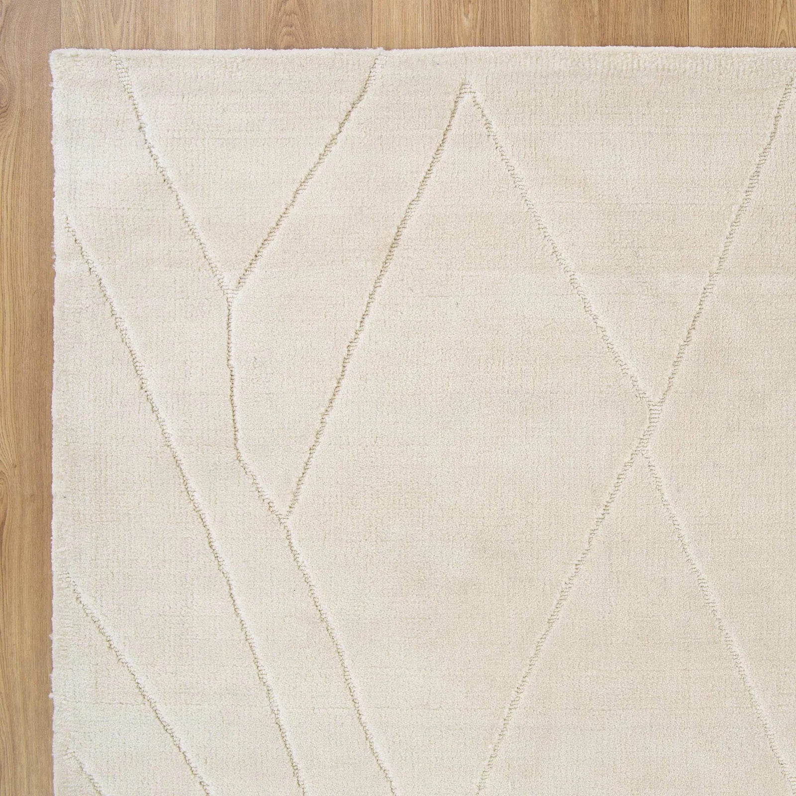 Beige rug with geometric pattern on a wooden floor
