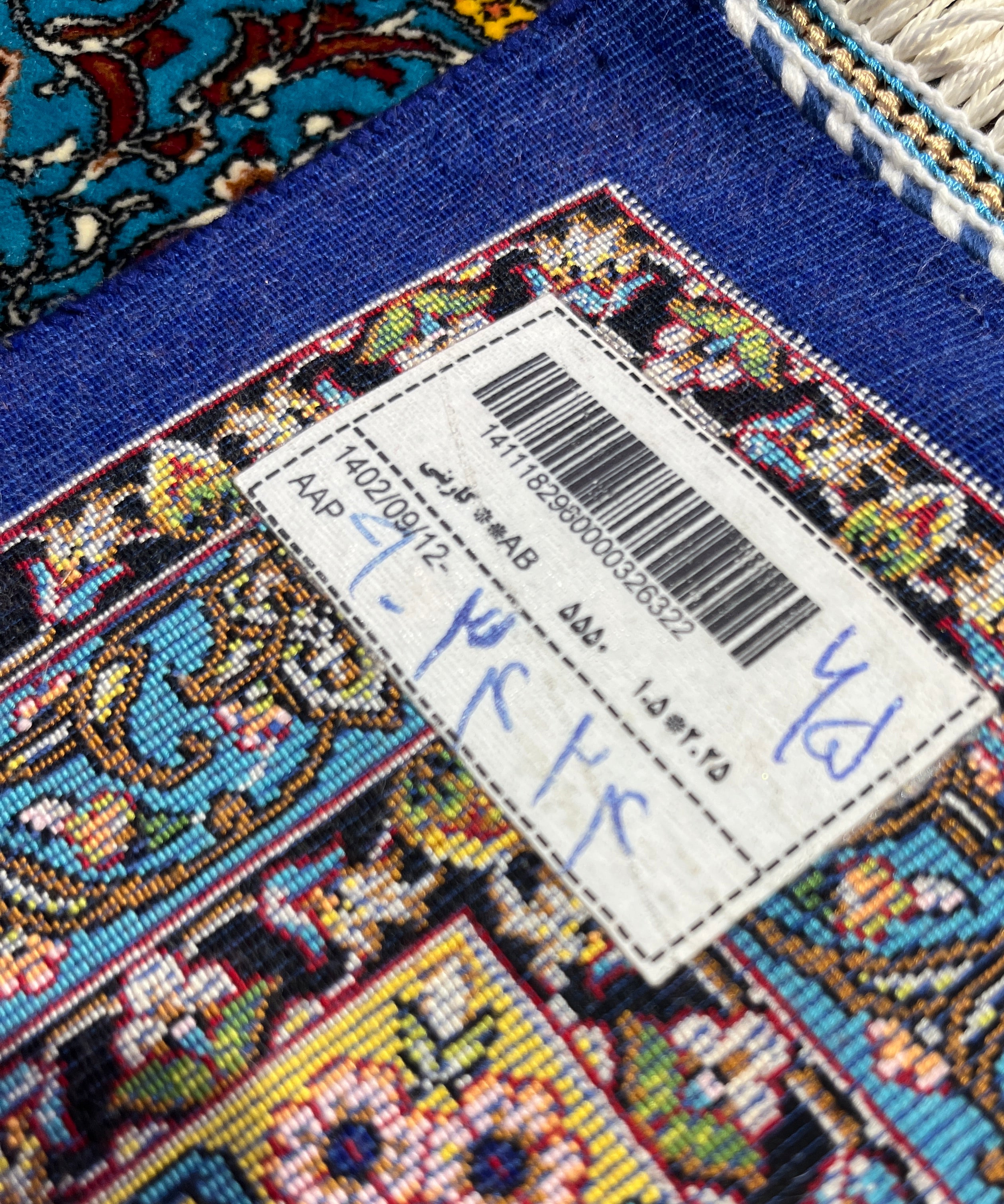 Close-up of a colorful rug with a label on a blue background