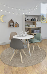 Modern dining area with round table and chairs in a room with string lights and shelves.