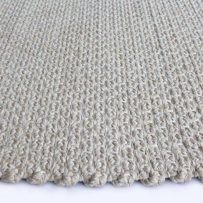 Close-up of a textured beige carpet on a white background