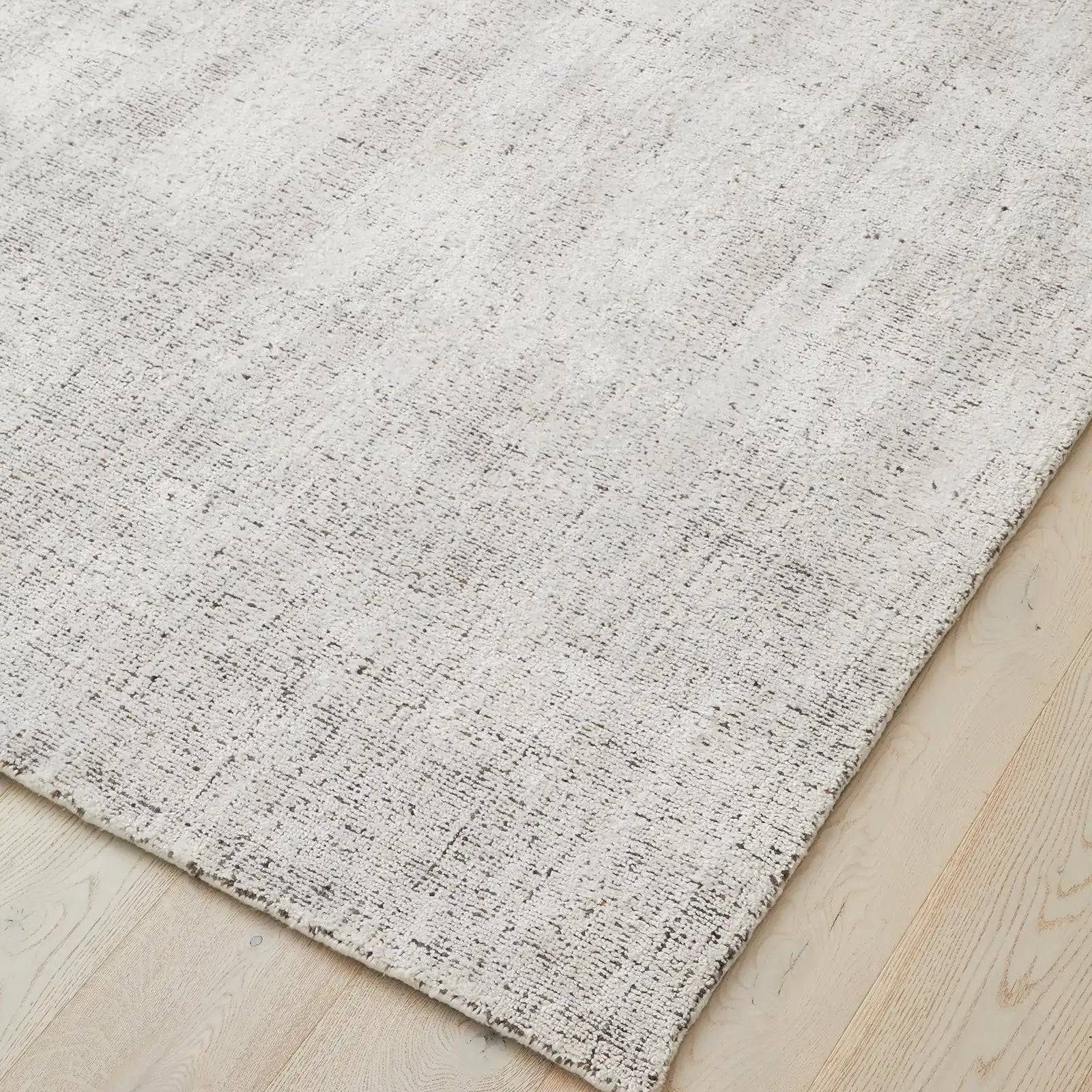 Angle shot of the rug, focusing on the loom-knotted craftsmanship and the fine, detailed finish.
