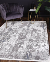 Bohemian Paradise grey-blue rug styled in a modern living room setup with a velvet chair and gold accent table.