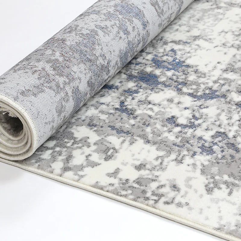 Rolled Bohemian Paradise rug showcasing its grey-blue hues and intricate pattern details.