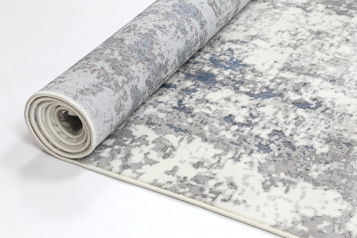 Rolled Bohemian Paradise rug showcasing its grey-blue hues and intricate pattern details.