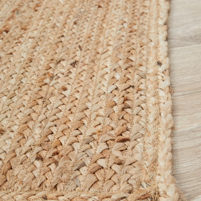 Close-up of a woven jute rug on a wooden floor