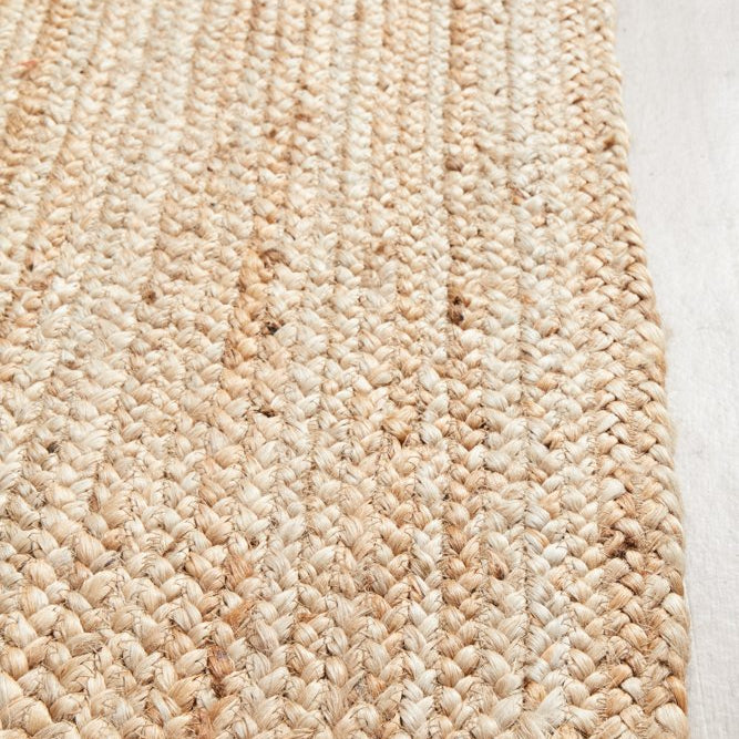 Close-up of a woven jute rug on a wooden floor