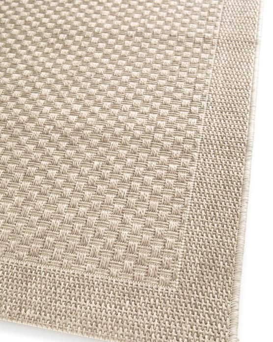 Close-up of a textured beige fabric corner on a white background