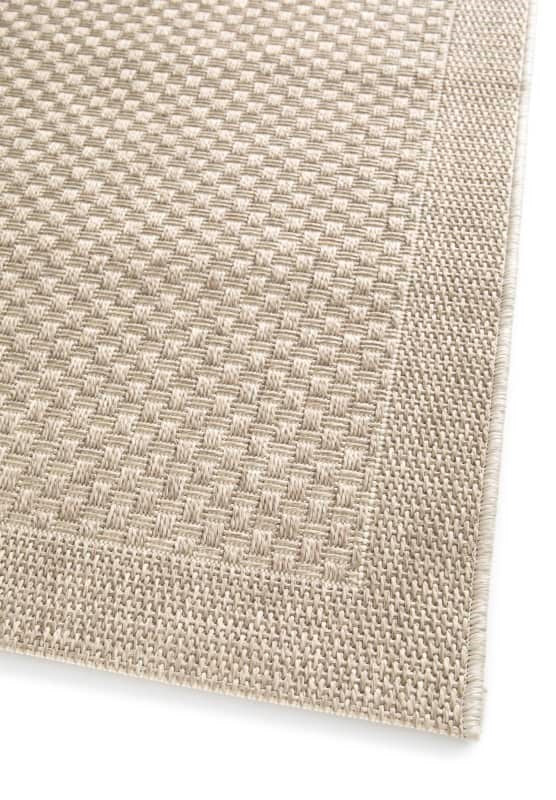Close-up of a textured beige fabric corner on a white background