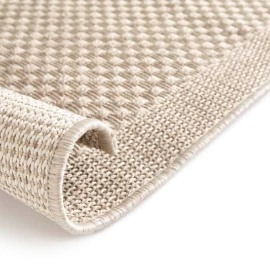 Close-up of a textured beige rug on a white background