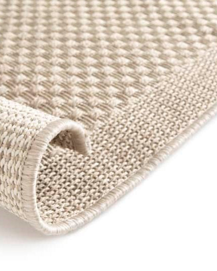 Close-up of a textured beige rug on a white background