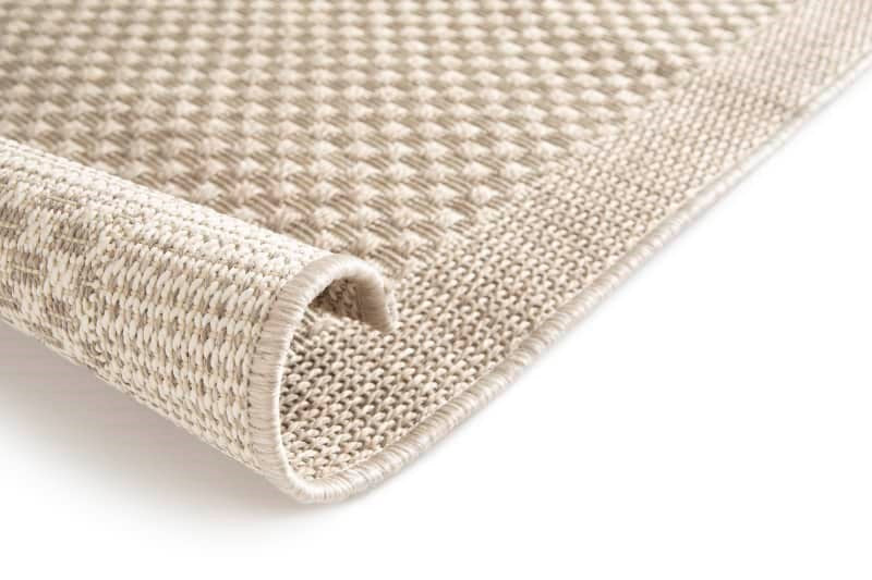 Close-up of a textured beige rug on a white background