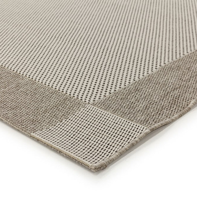 Close-up of a textured gray rug corner on a white background