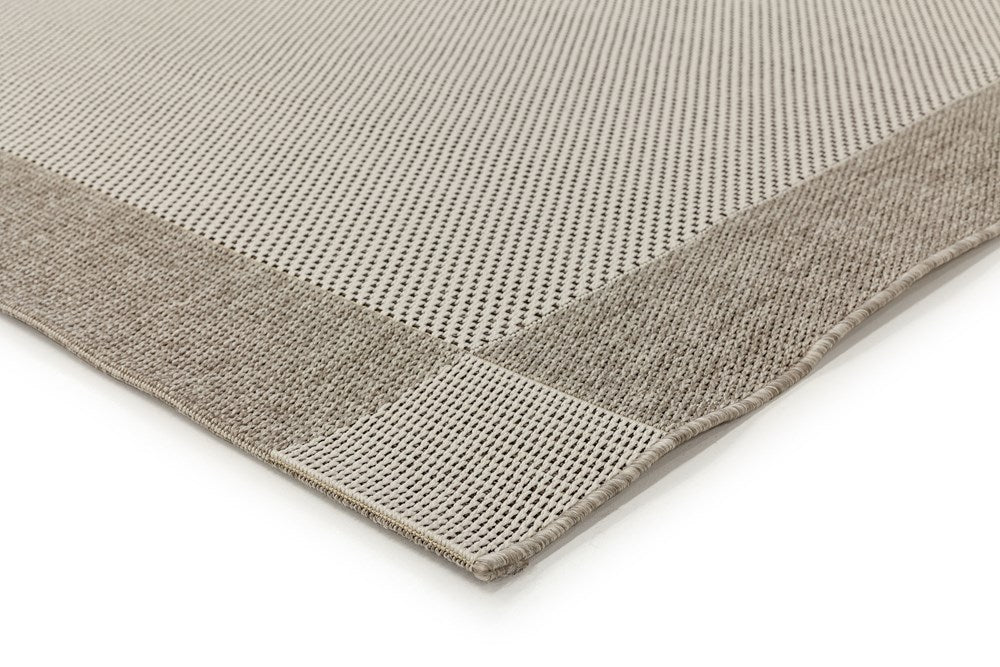 Close-up of a textured gray rug corner on a white background
