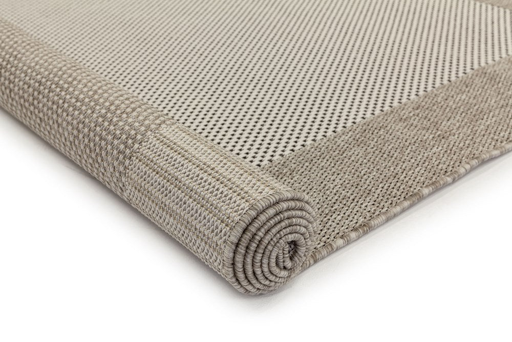 Rolled-up beige rug on a white background