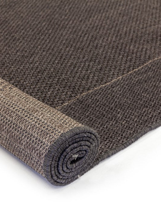Rolled-up brown textured rug on a white background