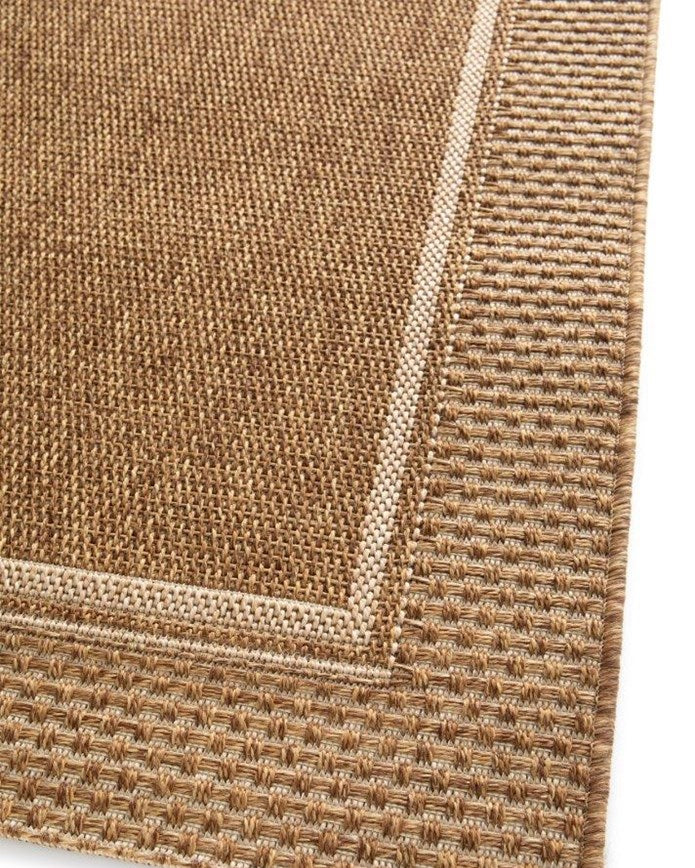 Close-up of a textured brown rug corner on a white background