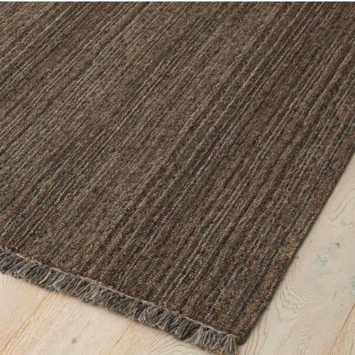 Brown textured rug on a light wood floor