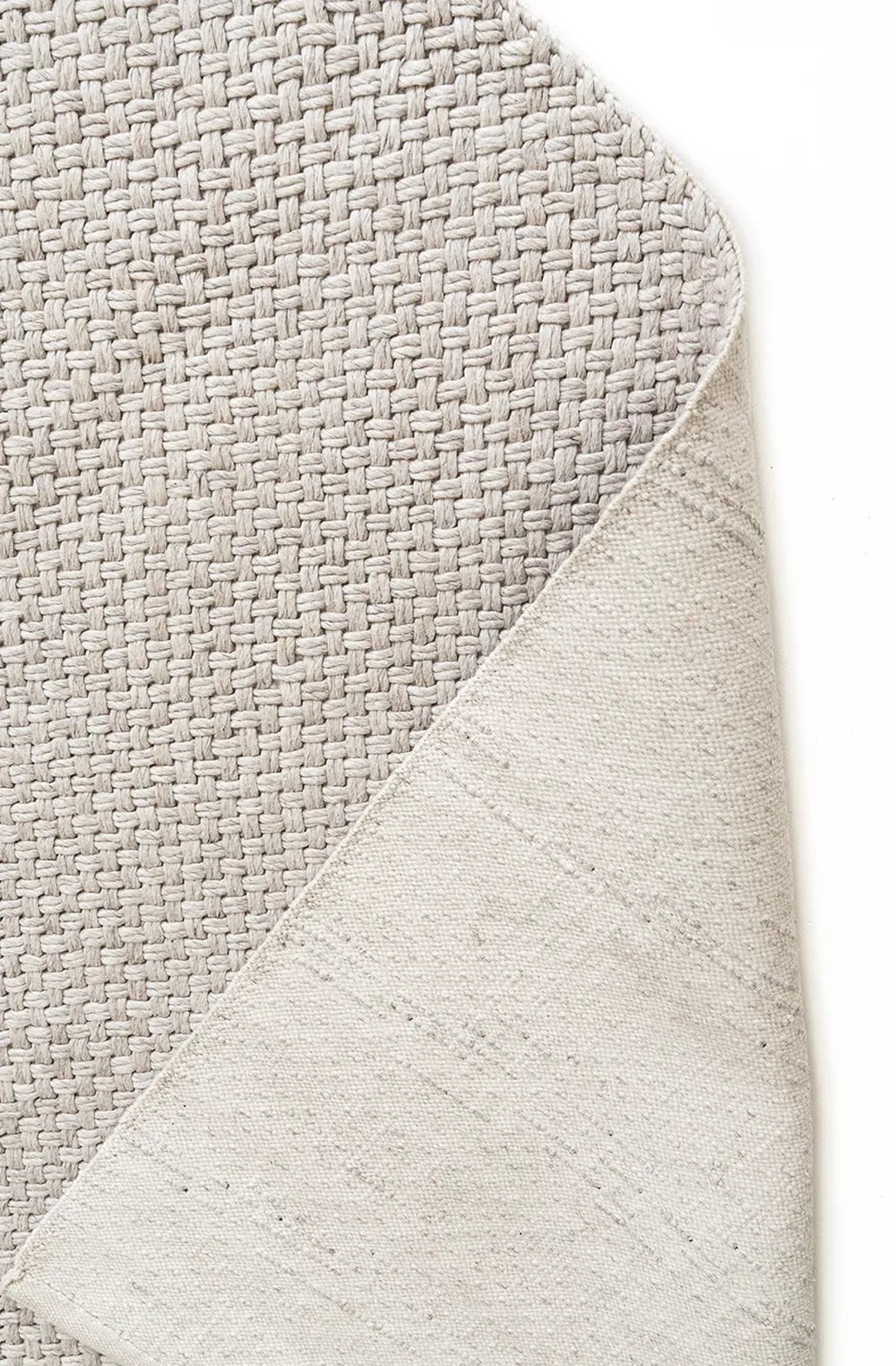 Close-up of a textured gray rug corner on a white background