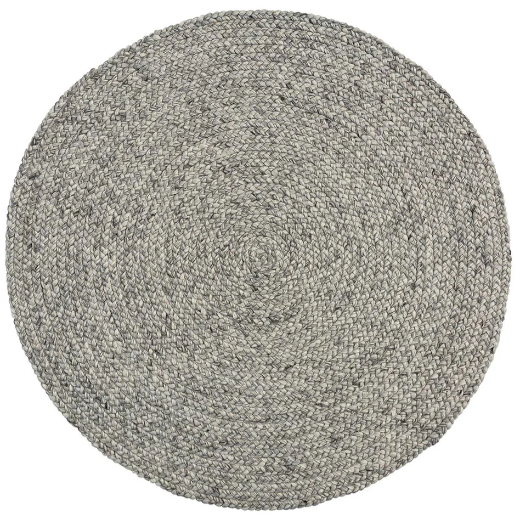 A round wool blend rug with a traditional cable knit style in a neutral monochrome color, handcrafted with a cotton cloth backing.