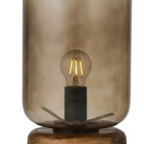 A table lamp with a smoky translucent glass shade and a round dark wood base, shown against a plain white background.