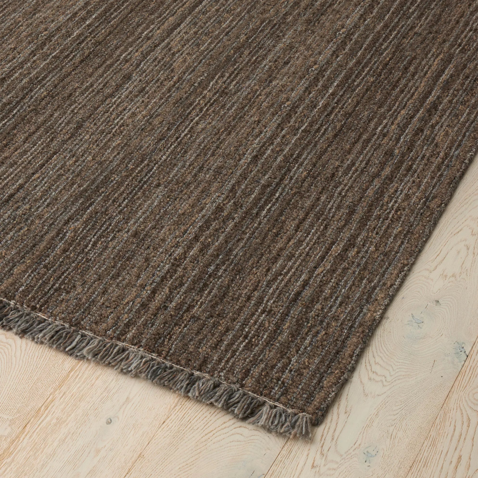 Brown textured rug on a light wood floor