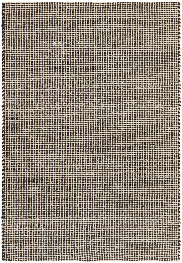 A black wool pile Skandi rug with a plain and textured pattern, hand loomed construction, and flat weave back.