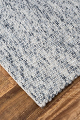 Rug with multiple colours of grey, white charcoal on timber flooring