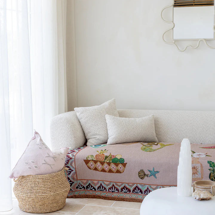 Living room with a white sofa, decorative pillows, and a colorful blanket.