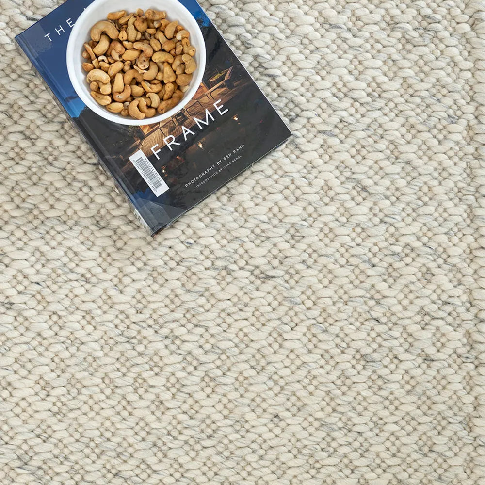 Book titled 'The Frame' on a textured rug