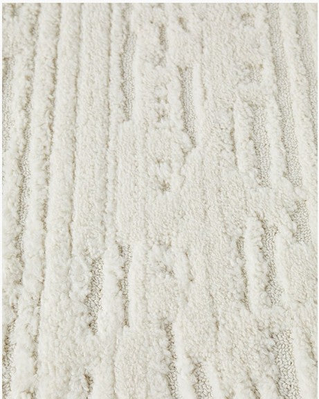 Textured beige rug on a concrete floor