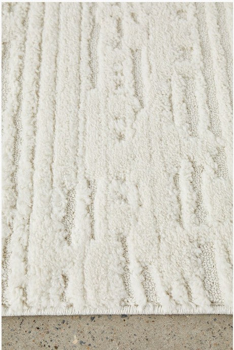 Textured beige rug on a concrete floor