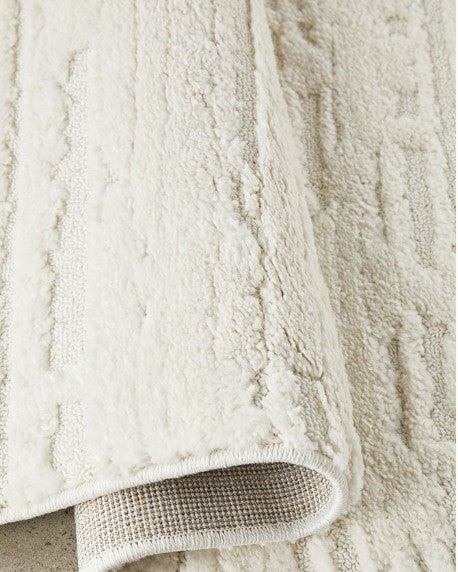 Close-up of a textured beige bath mat on a concrete surface