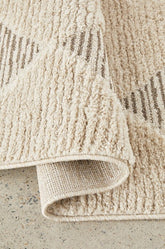 Close-up of a textured beige rug on a concrete floor