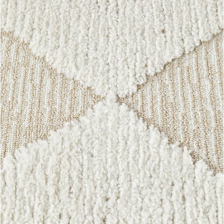 Close-up of a textured beige and white rug with geometric pattern