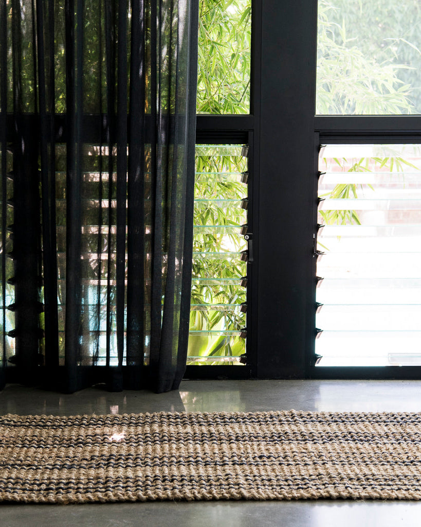 Rug on a floor with glass windows and bamboo in the background