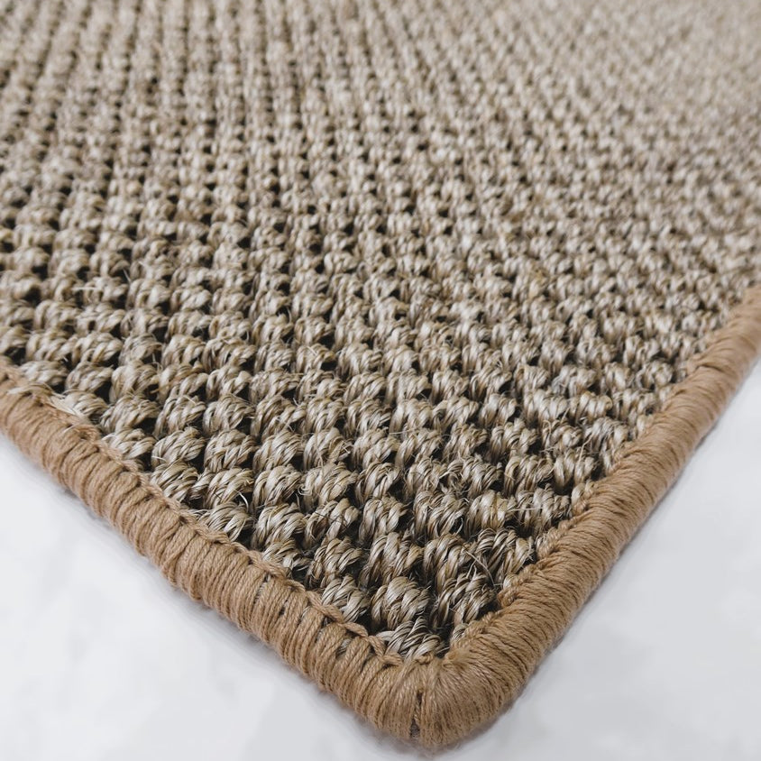 Close-up of a textured beige rug with a white background