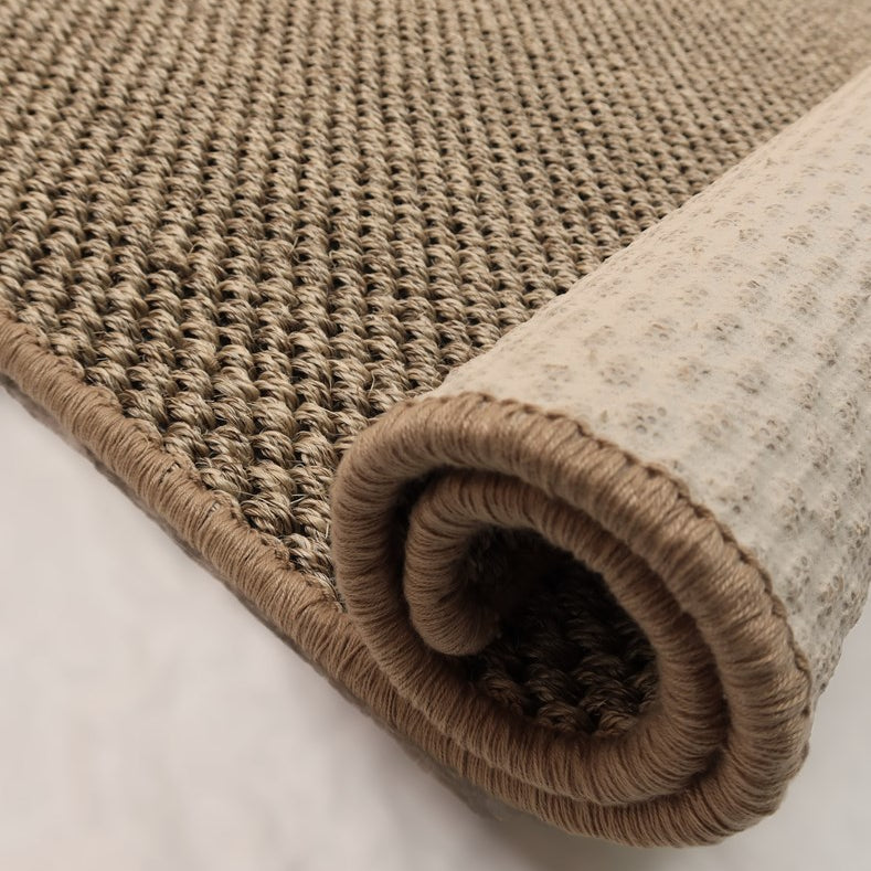 Rolled-up beige carpet on a light background