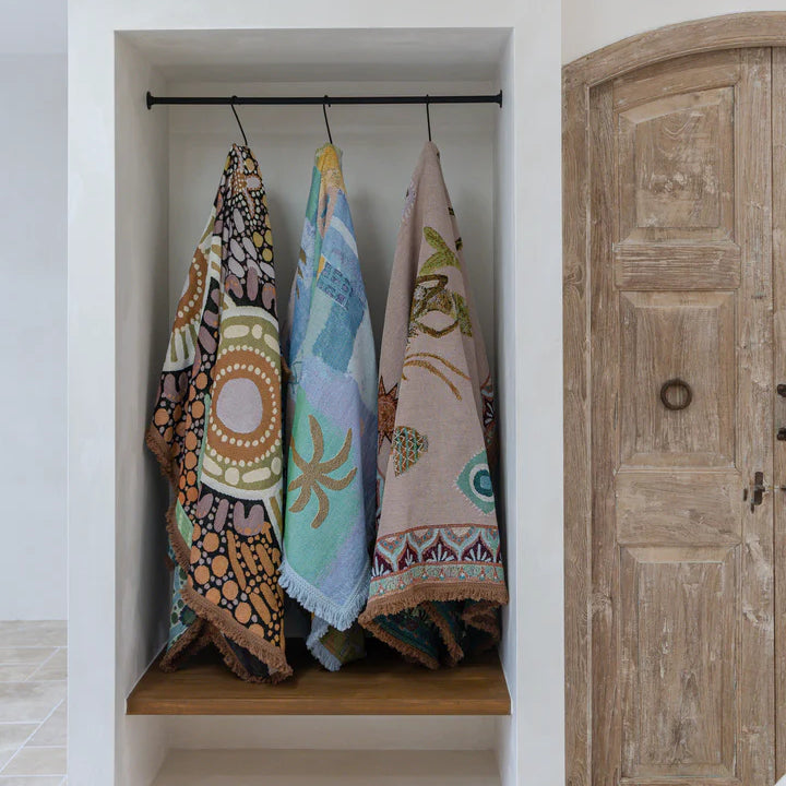 Colorful towels hanging on a rack inside a bathroom with a wooden door.