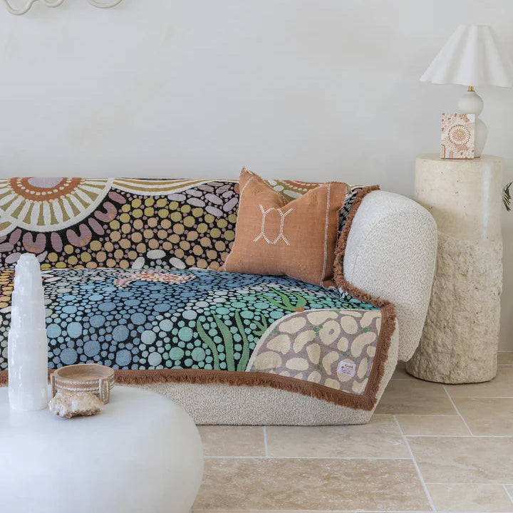 Colorful patterned sofa with decorative pillows in a living room setting.