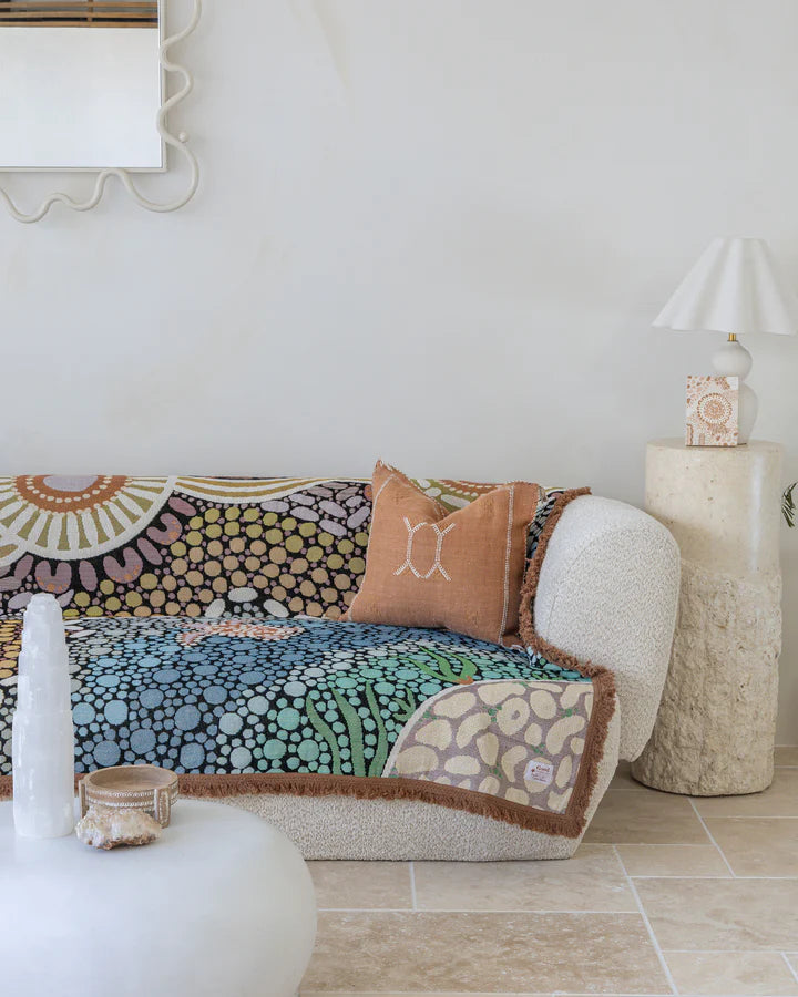 Colorful patterned sofa with decorative pillows in a living room setting.