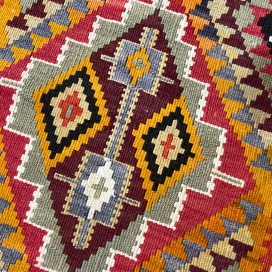 Close-up of a colorful geometric patterned fabric with vibrant colors.