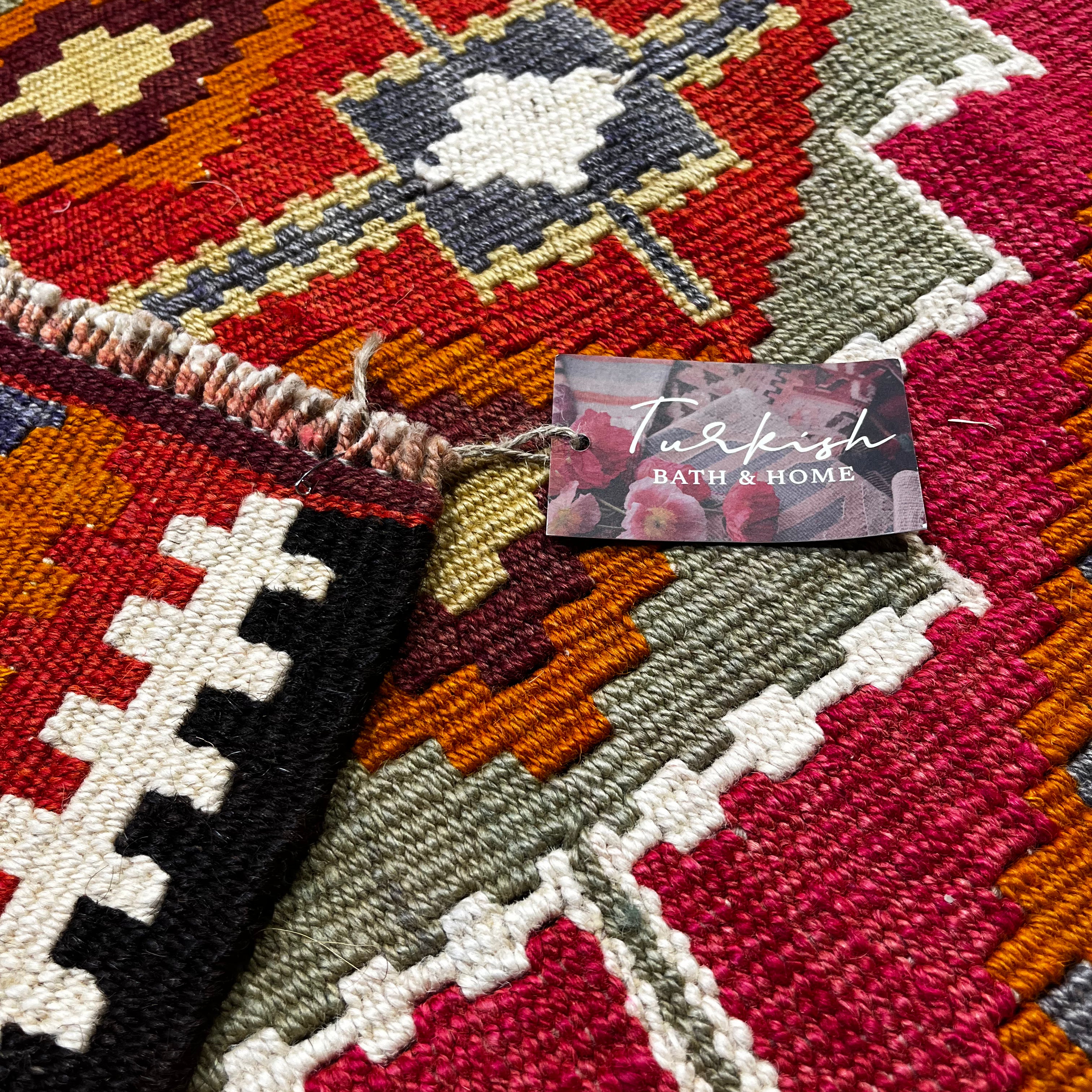 Close-up of a Turkish bath and home product label on a patterned rug.