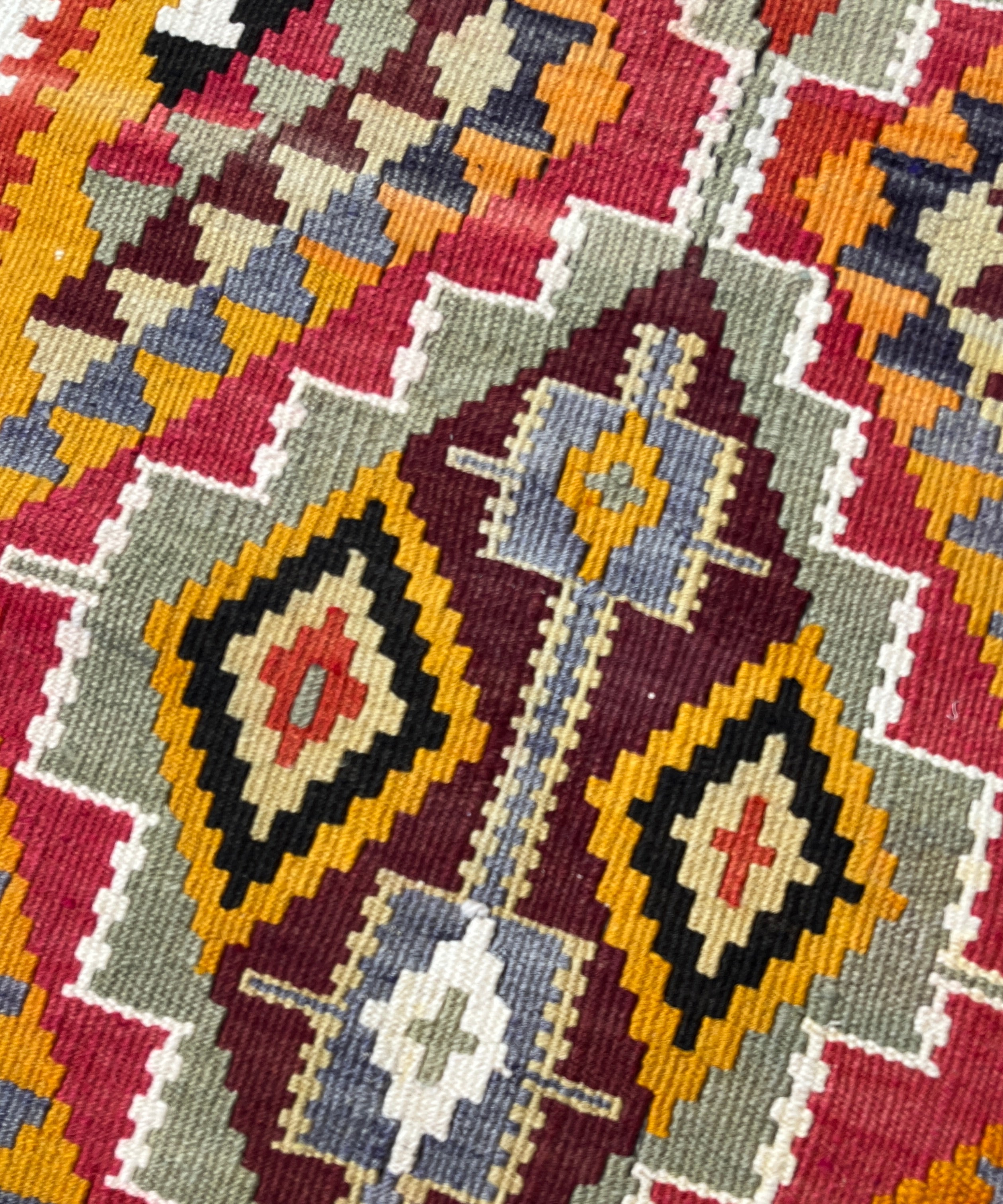 Close-up of a colorful geometric patterned fabric with various colors.