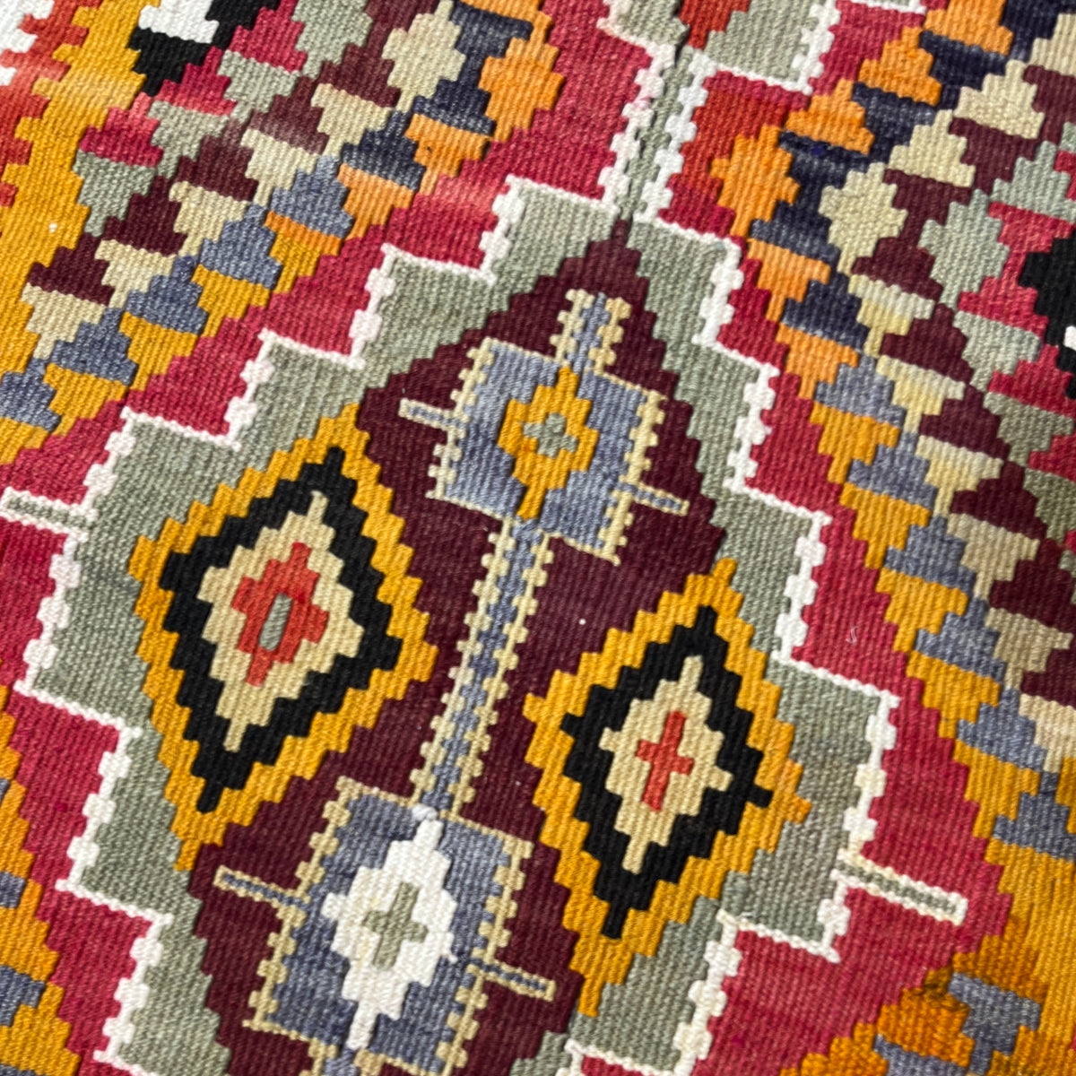 Close-up of a colorful geometric patterned fabric with various colors.