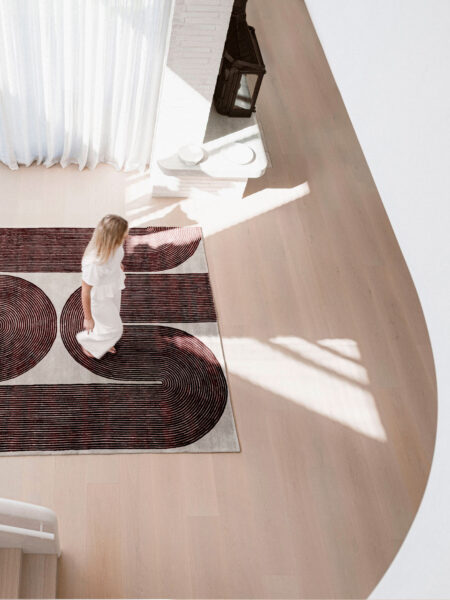 Woman walking on a patterned rug in a modern interior setting