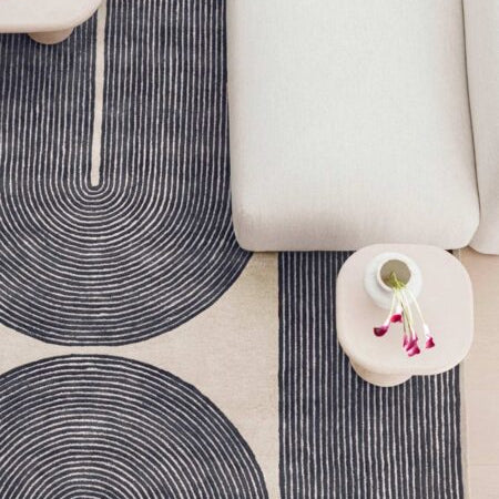 Patterned rug with concentric circles on a neutral-colored floor.
