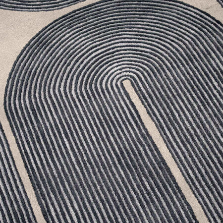 Close-up of a textured rug with circular patterns in black and beige.