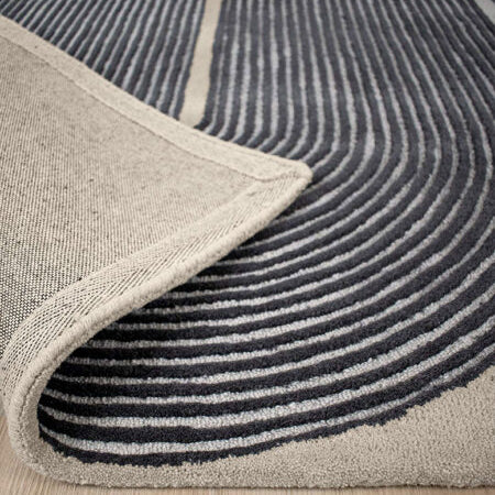 Close-up of a gray and black patterned rug on a wooden floor