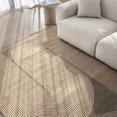 Modern living room with a circular patterned rug and a beige sofa.