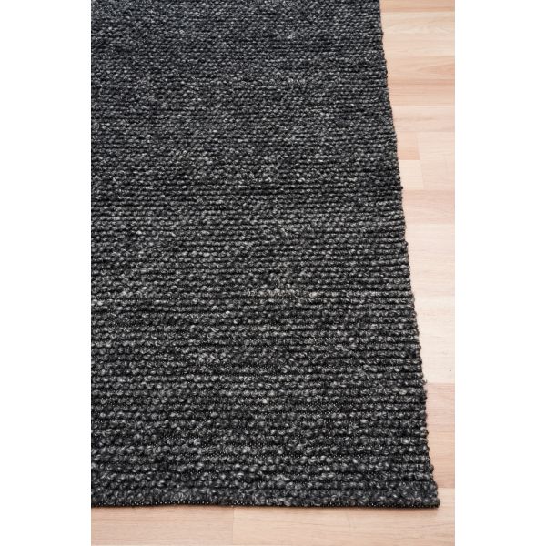 Dark gray textured rug on a light wooden floor